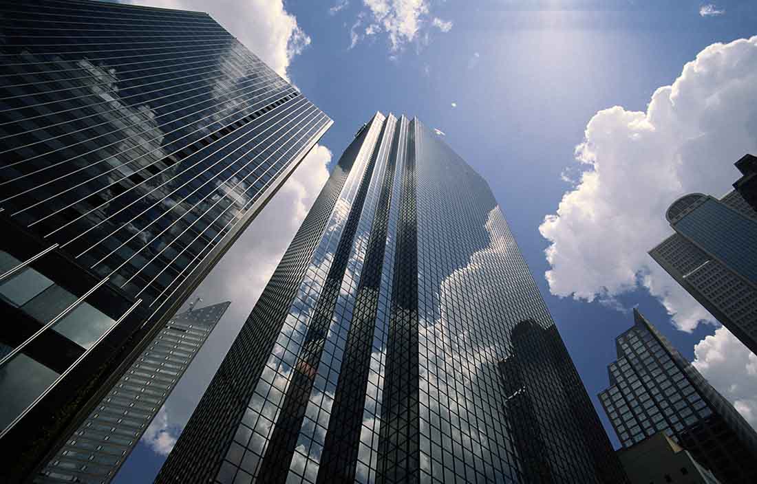 Looking up at buildings with clouds