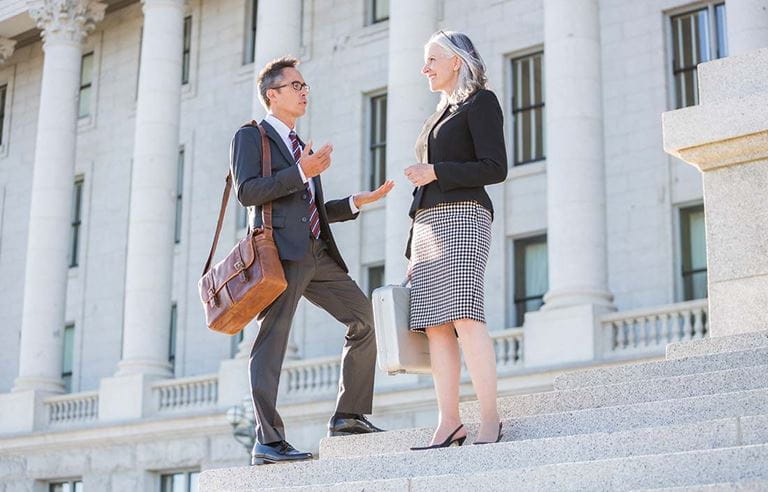 Two tax professionals standing on steps discussing cost segregation.