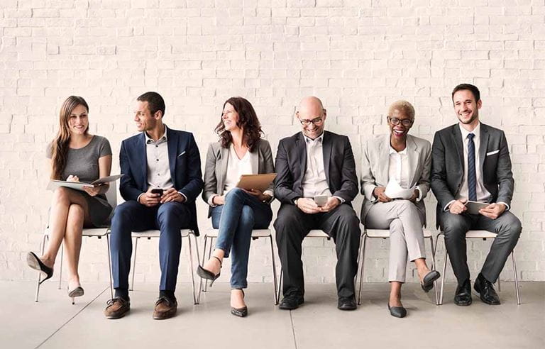 team members sitting in a row smiling