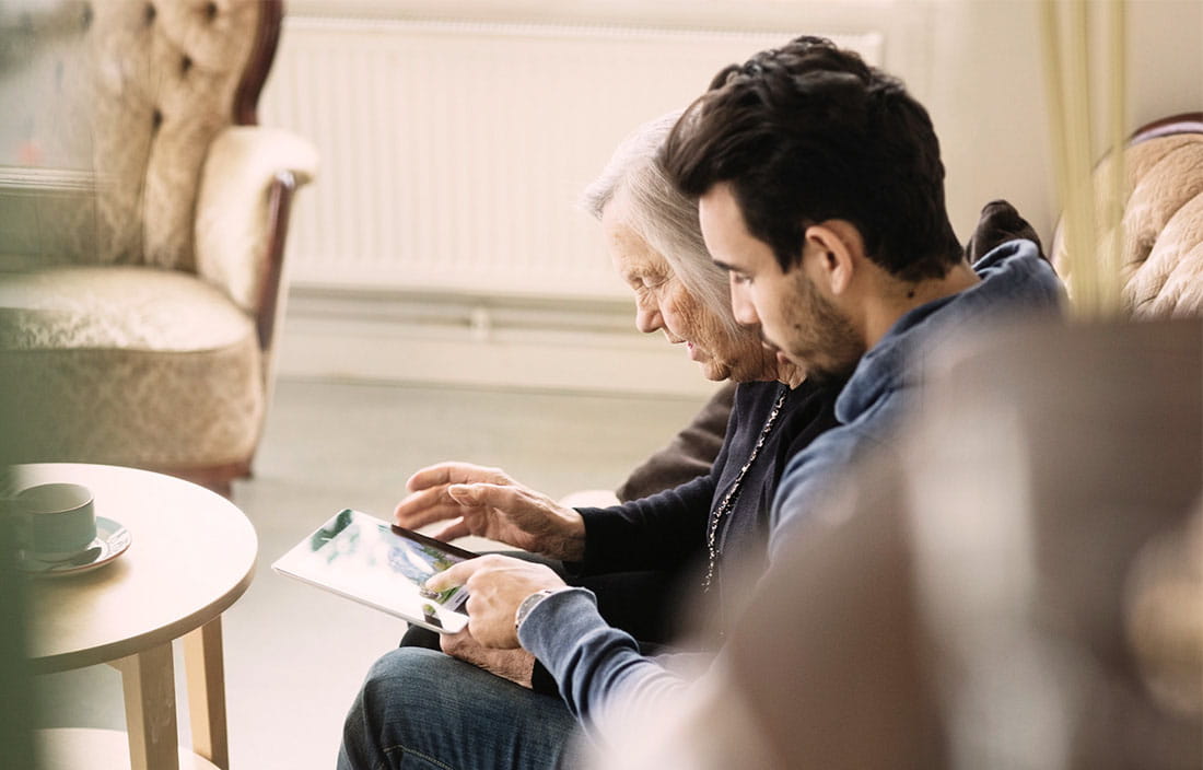 Senior mother looking at a clipboard with adult son