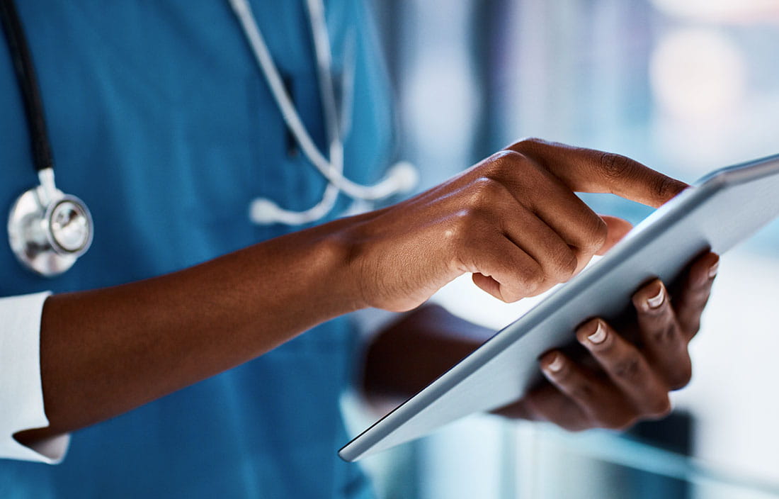 Healthcare professional checking tablet computer.