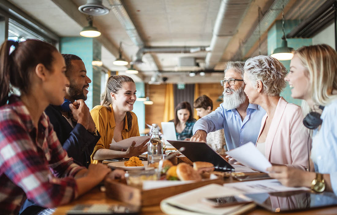 Group of people eating lunch at restaurant.