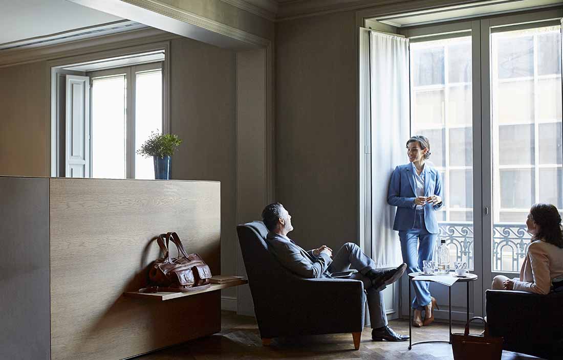 Group of people having a discussion in a hotel room.