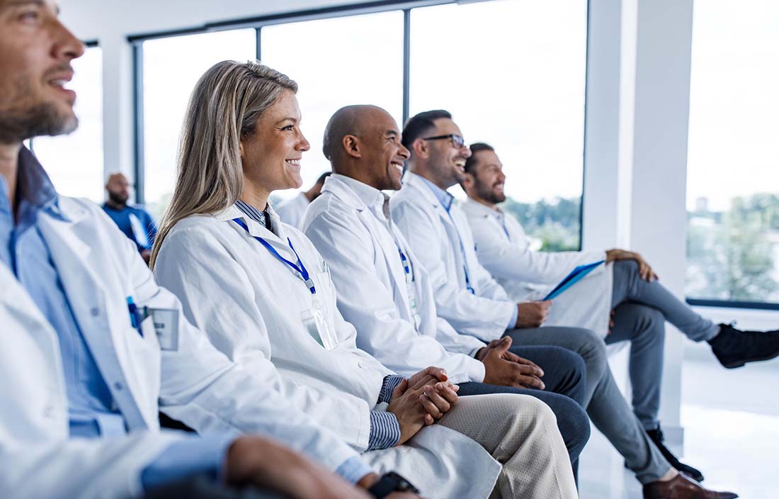 Group of hospital leaders sitting down and listening to a discussion on data analytics.