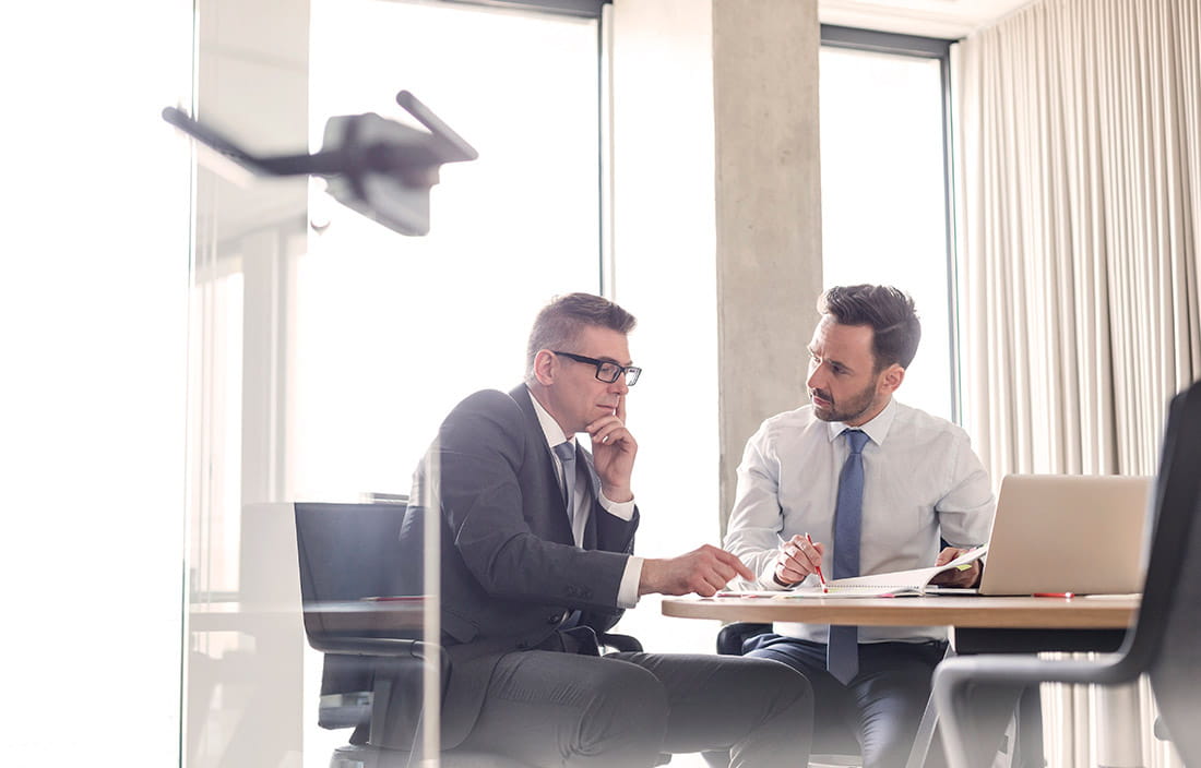 Two business professionals reviewing their loan covanant in an office. 