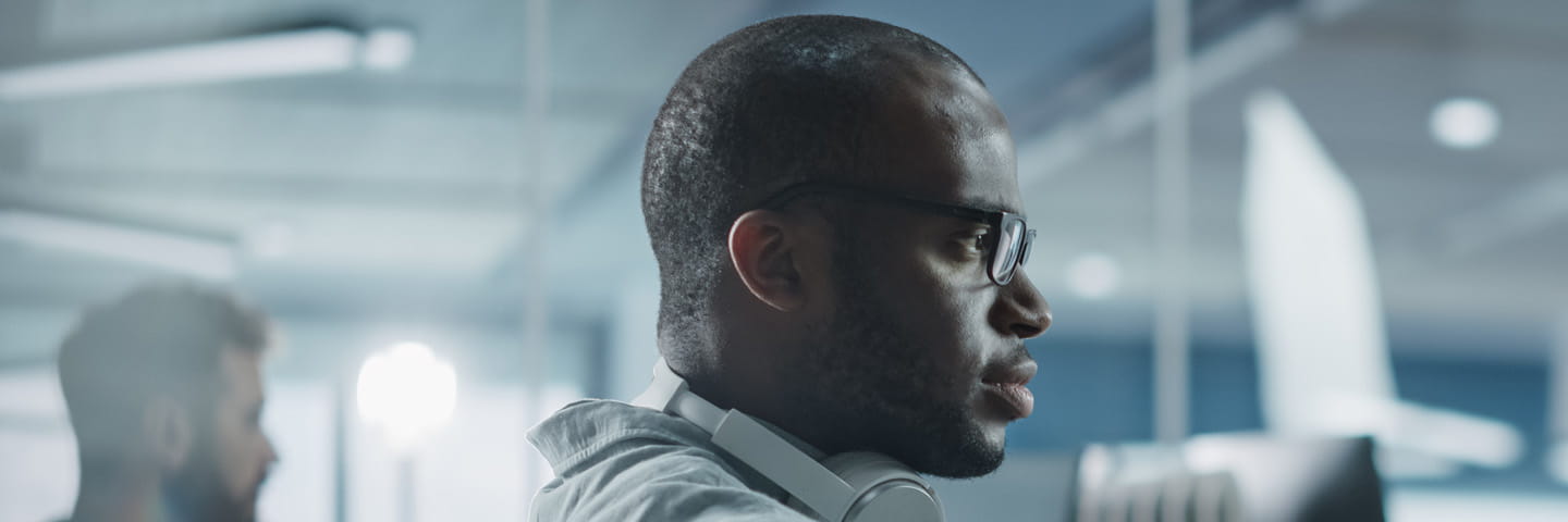 View of cybersecurity professional working on their computer in a modern office.