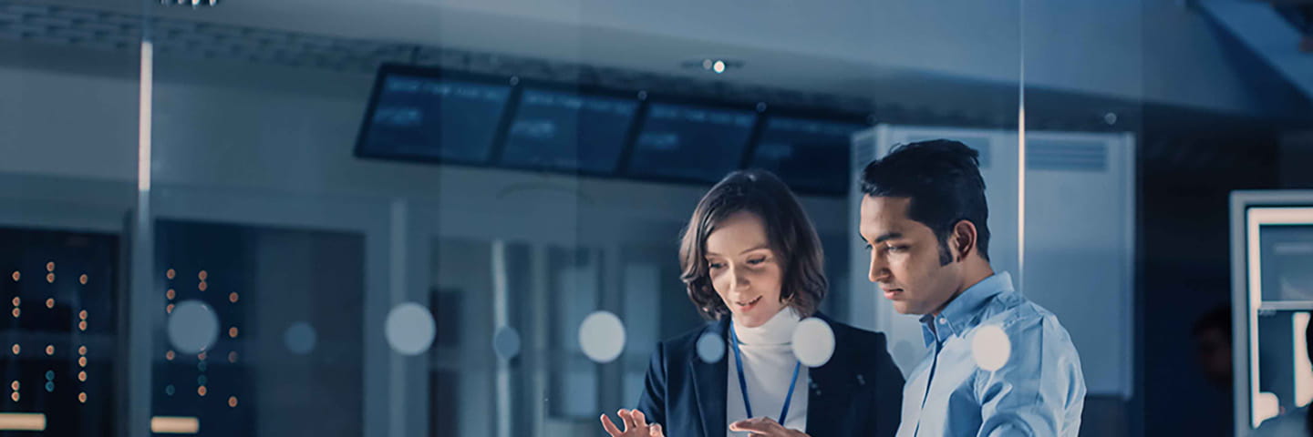 Two business professionals viewing information on a tablet together.