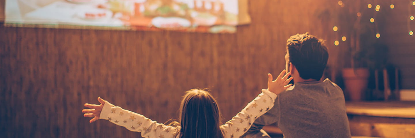 A parent and a child watching TV together.