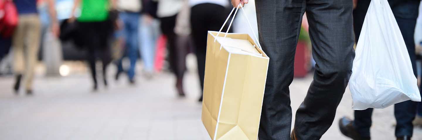 People carrying shopping bags in a busy city.