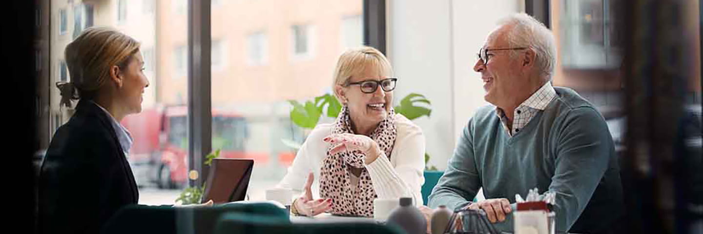 A couple meeting and laughing with a financial planner.