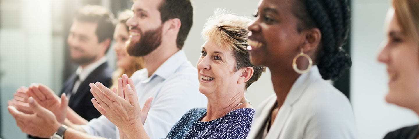 Group of business professionals clapping and smiling