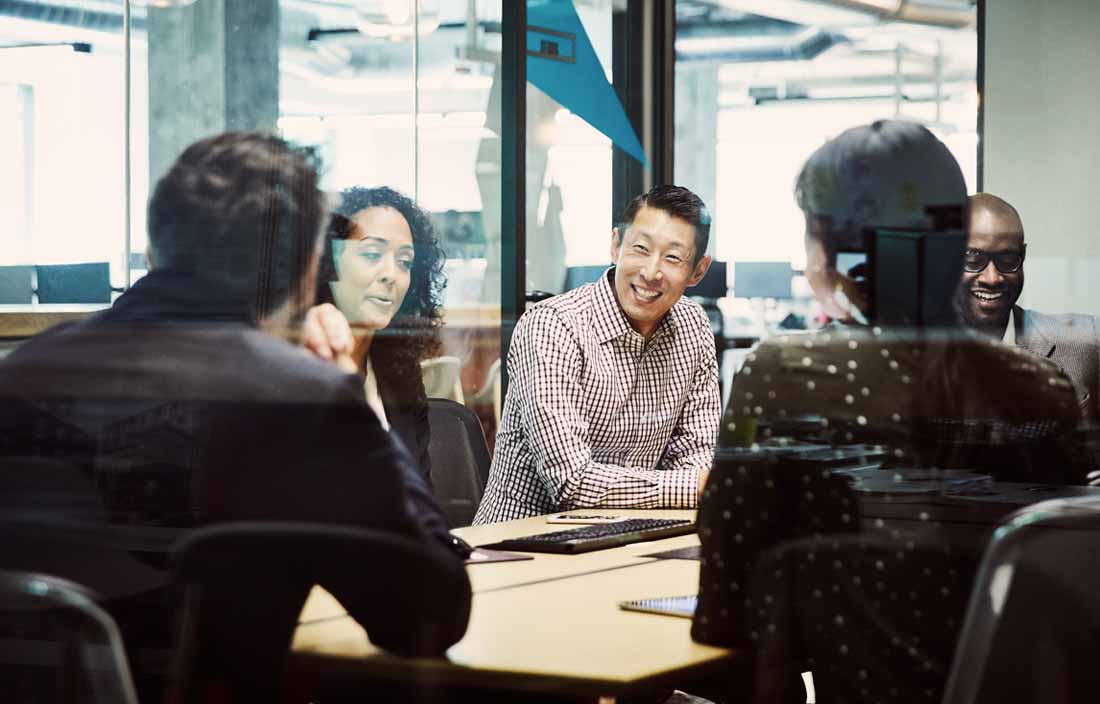 A group of multiethnic business professionals meeting together and smiling.