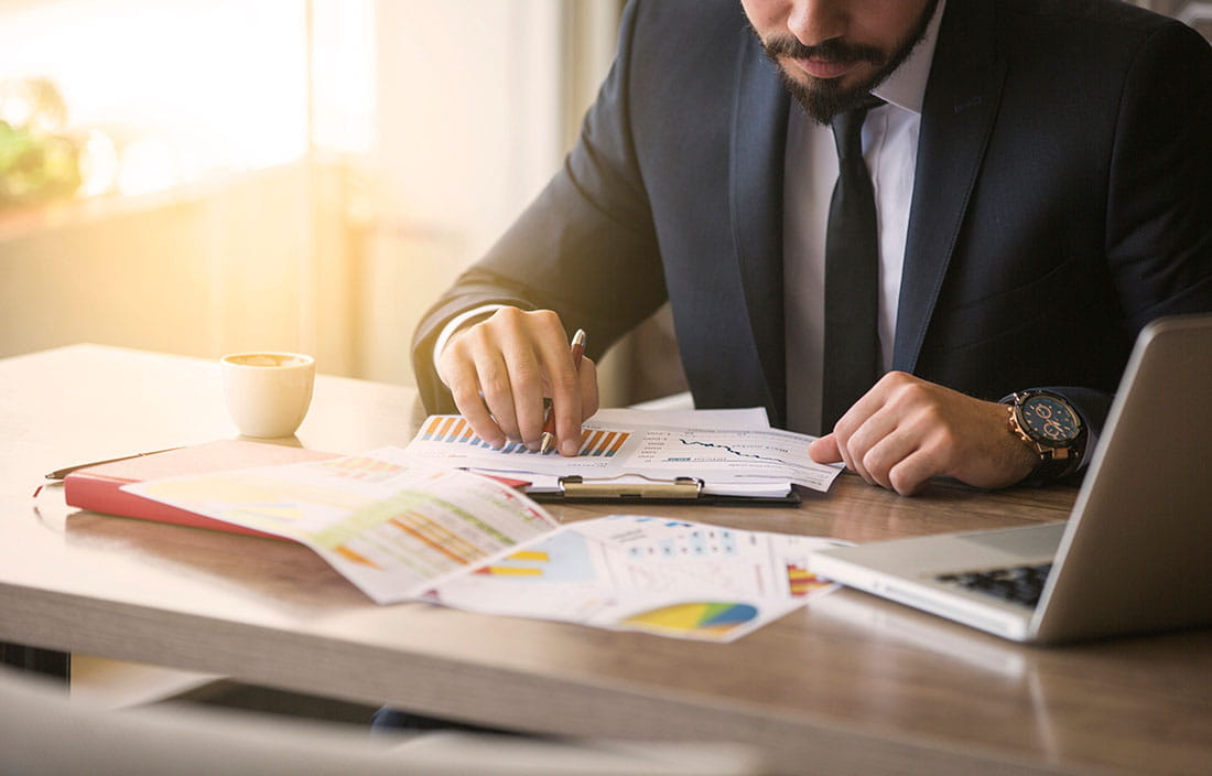 Image of businessman reviewing documets at his desk.