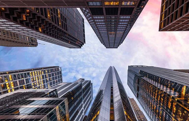 Point of view photo looking up at tall city skyscrapers. 