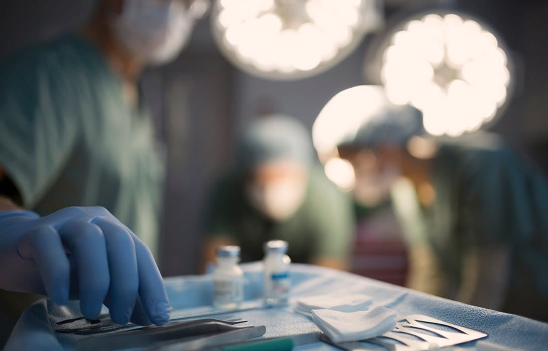 Surgeon reaching for medical tool in an operating room. 