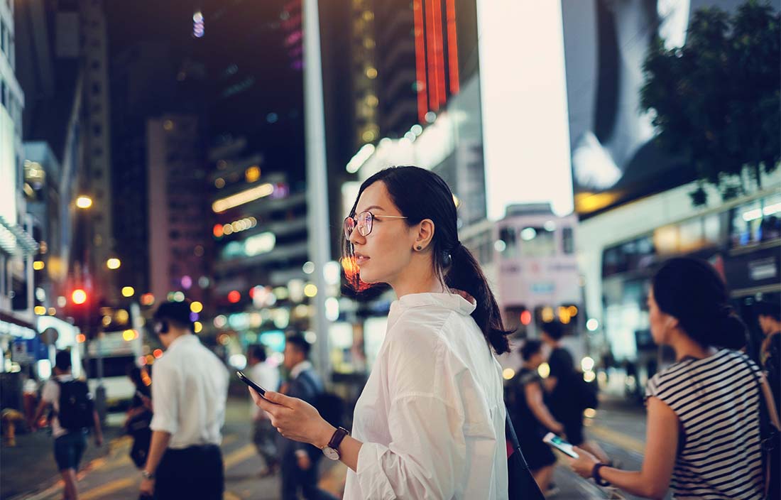 Picture of a young woman navigating the streets of a smart city. 