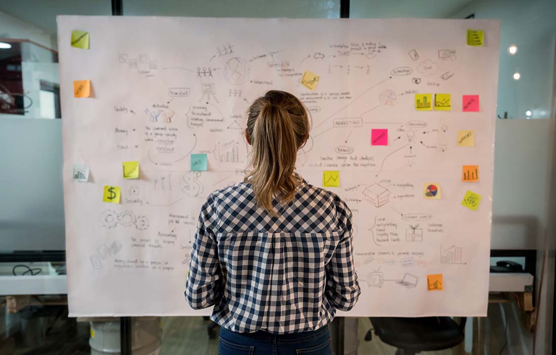 A woman looking at a chart and assessing her private equity exit plan. 