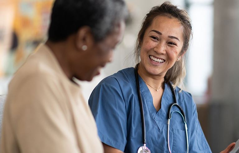 Nurse smiling and helping their patient.