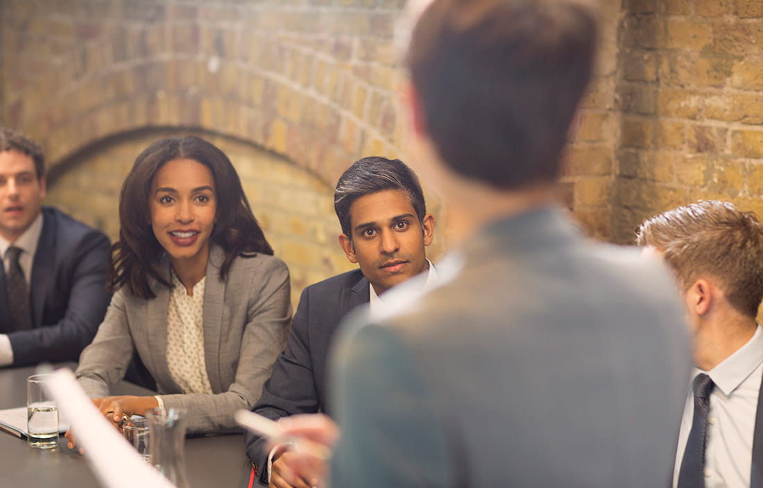 A group of employees having a meeting in a conference room discussing the Mexico tax incentives news. 