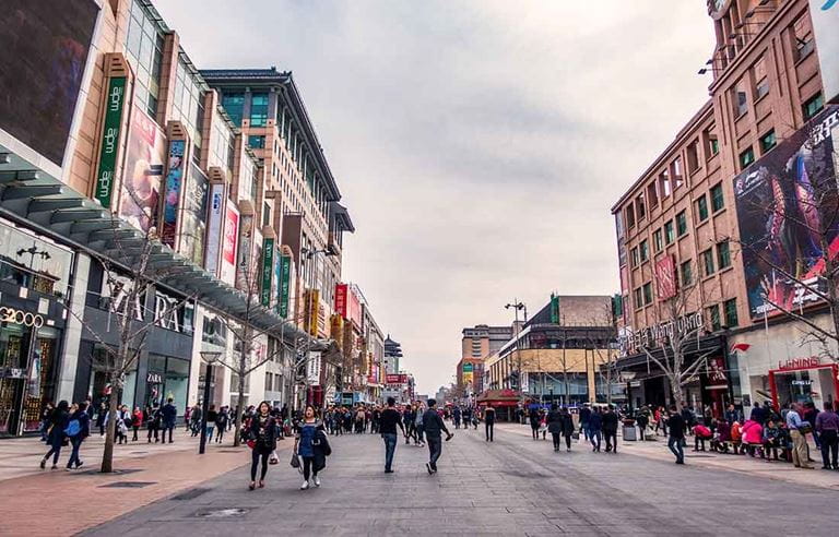 Pedestrians walking down street in Beijing