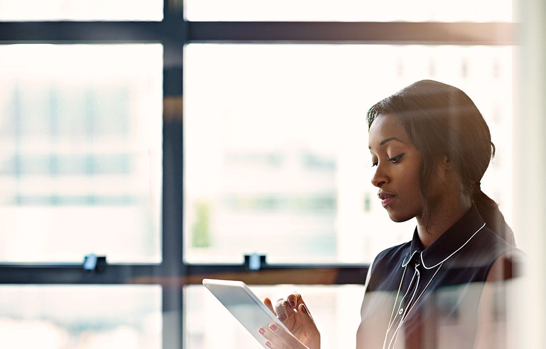 Woman sitting and looking at a tablet