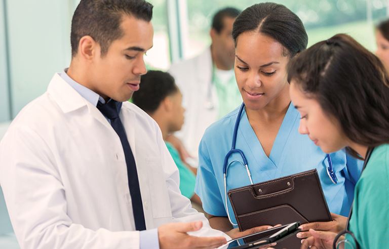 A doctor and nurses looking at a tablet