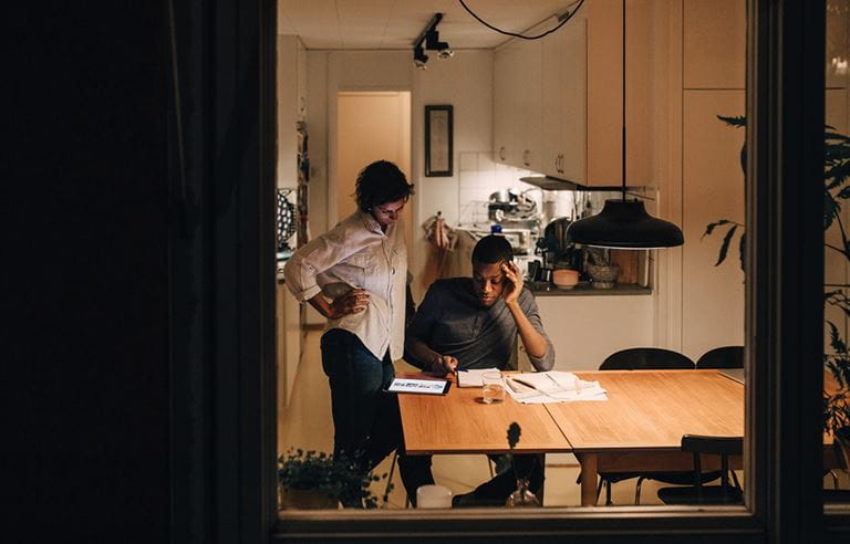 Two people at a table looking over papers