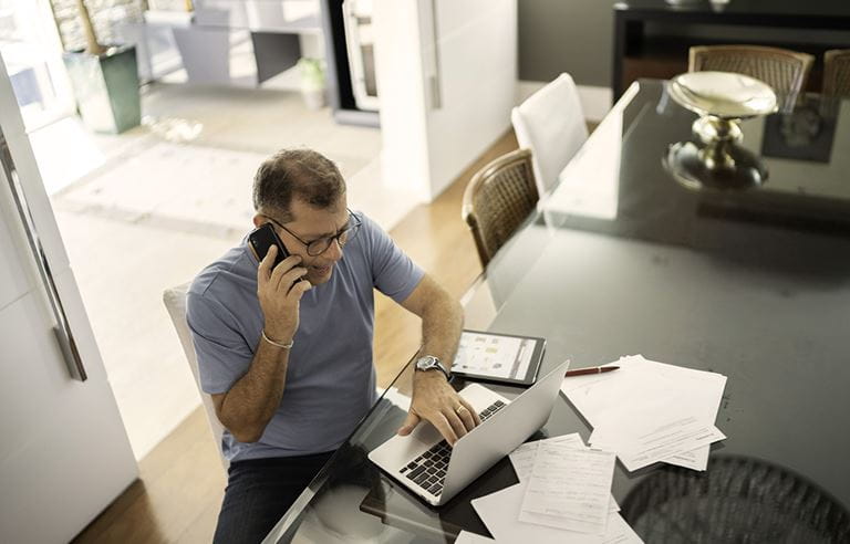 Man sitting at a table talking on the phone