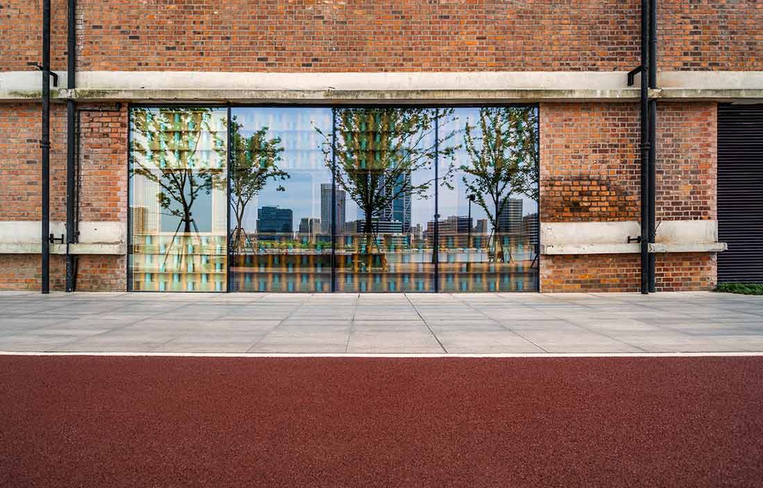 Street view of a sidewalk and storefront glass window display.