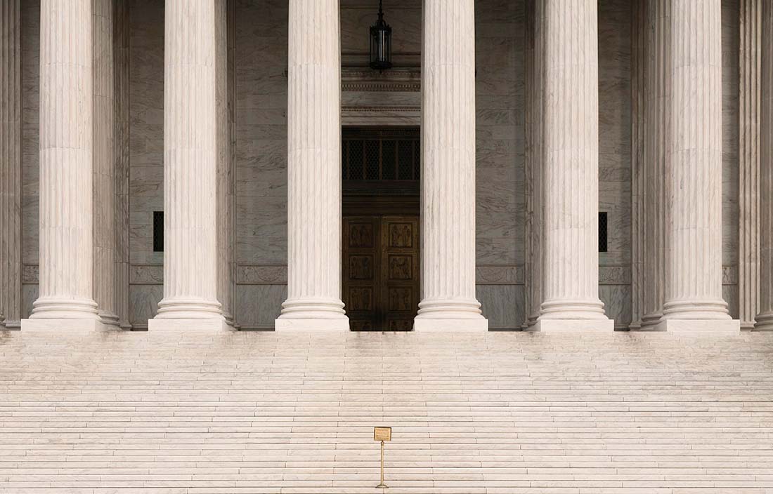 Steps leading up to a government building with column supports. 