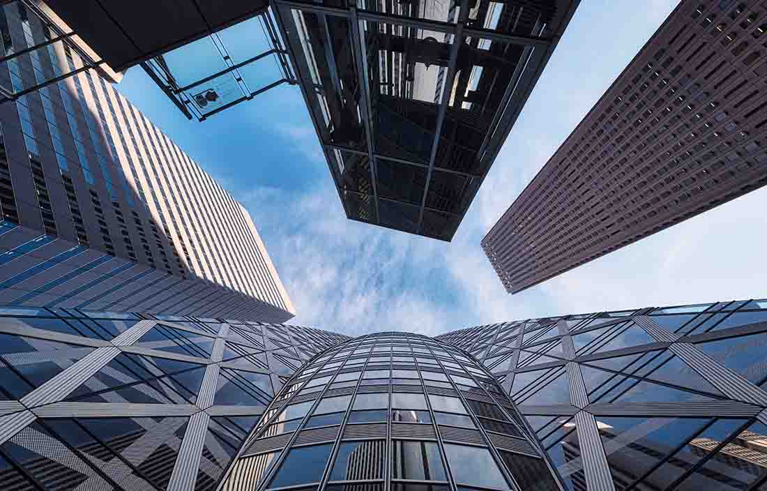 View of skyscraper buildings in a downtown area looking up at them.