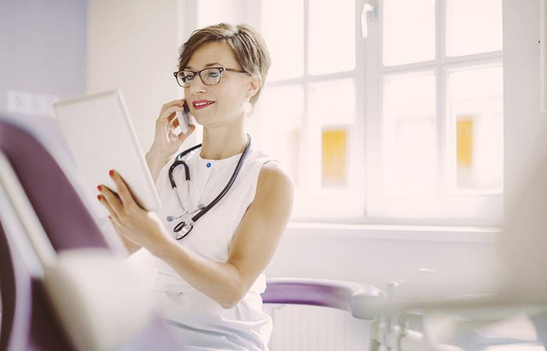 Medical staff member using a tablet to engage in telehealth care.