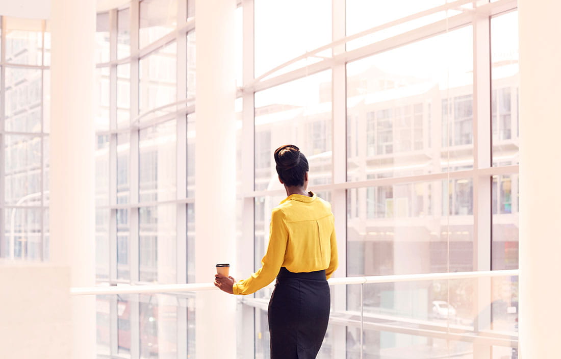 Municipal worker taking a break in a lobby area looking outside the building.