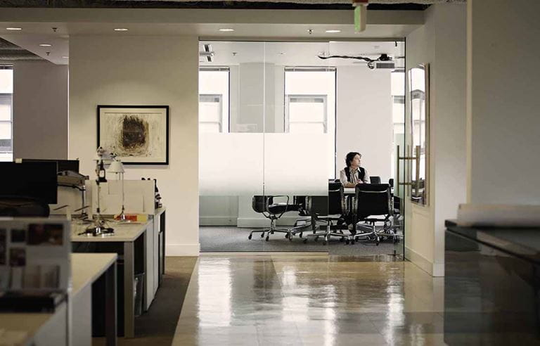 Man sitting in an empty glass conference room