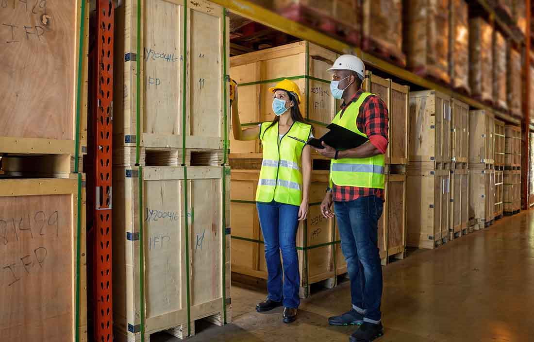 Two construction workers looking at pallets