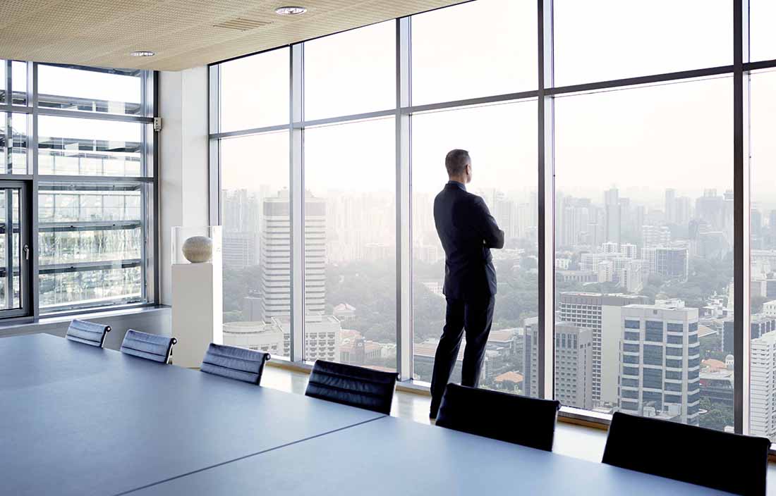 Man standing next to a wall of windows