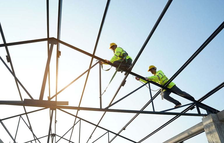 Construction workers on frame of house.