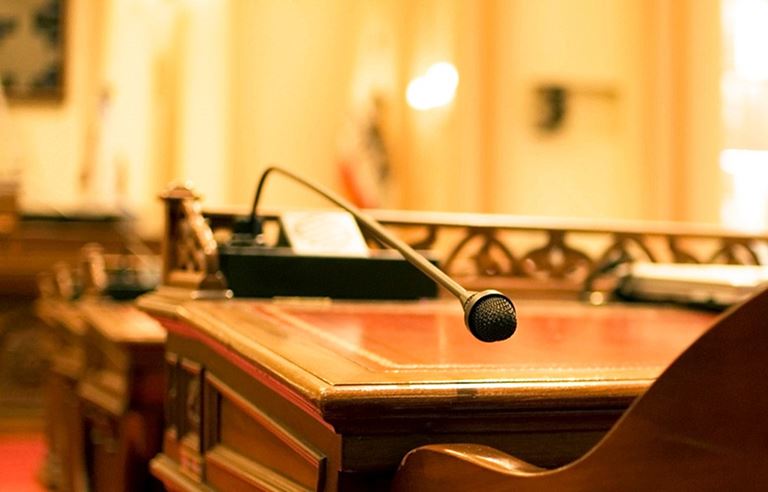 Close-up view of a wooden podium and microphone.