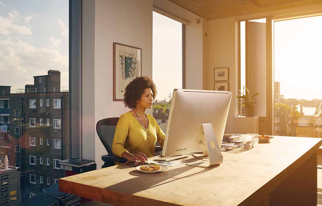 Business professional using desktop computer at desk.