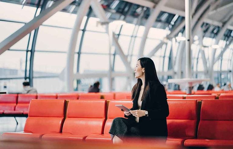 Business professional sitting in a waiting area at an airport.