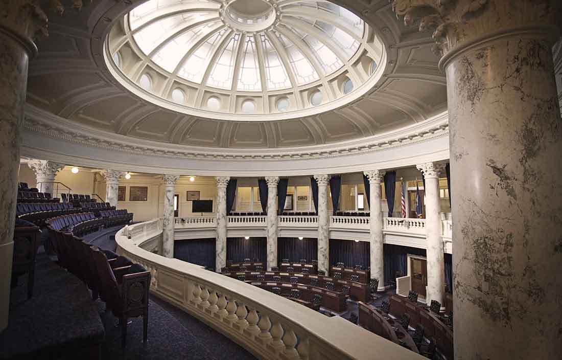 Government building room with marble archways and auditorium seating.