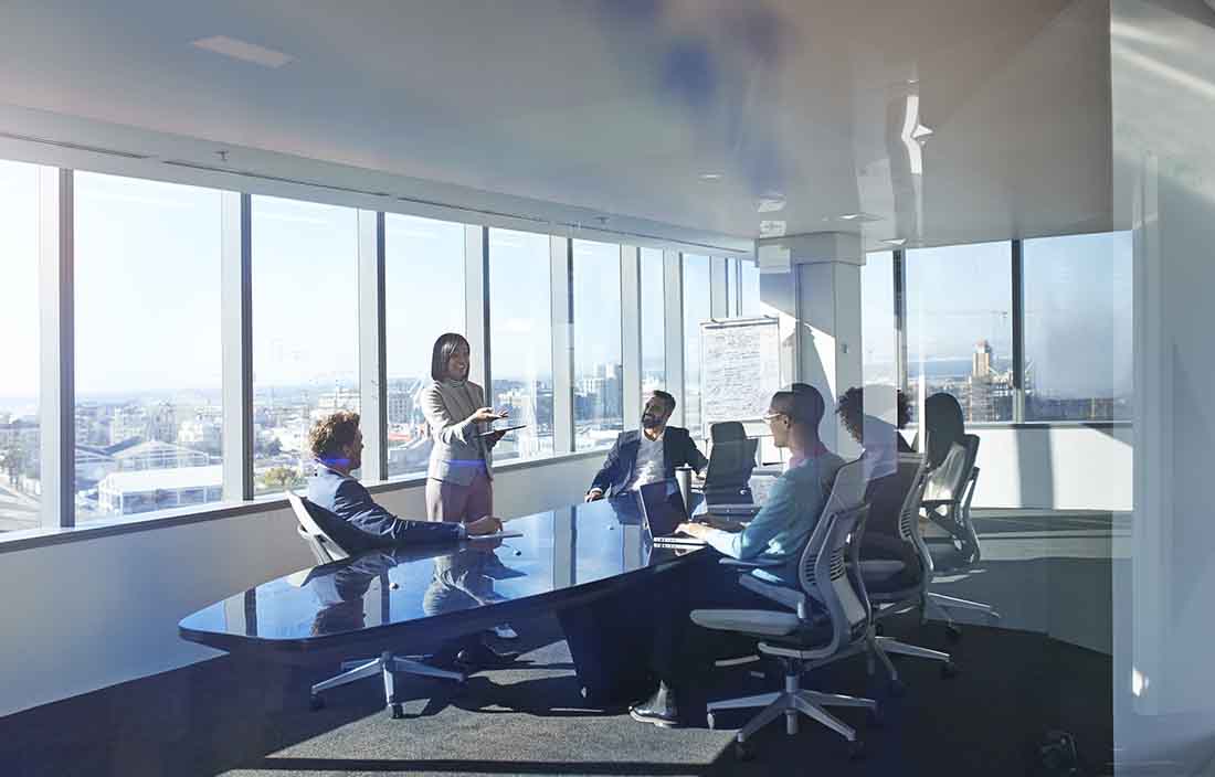 Business professionals in a conference room having a meeting sitting at a conference table.