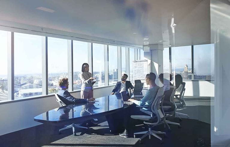 Business professionals in a conference room having a meeting sitting at a conference table.