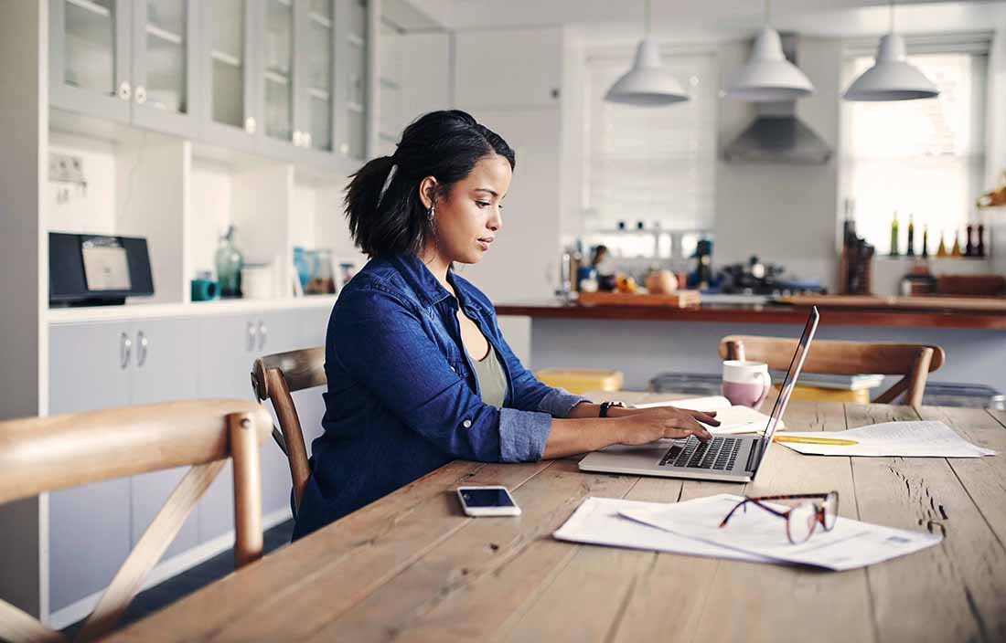 Business professional using a laptop computer in their home office.