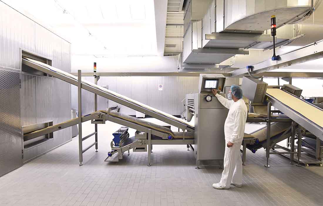 Manufacturing worker standing next to machinery.