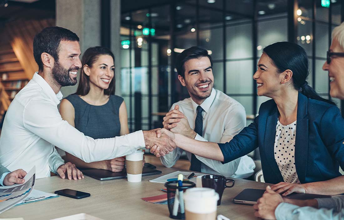 Business professionals shaking hands together.