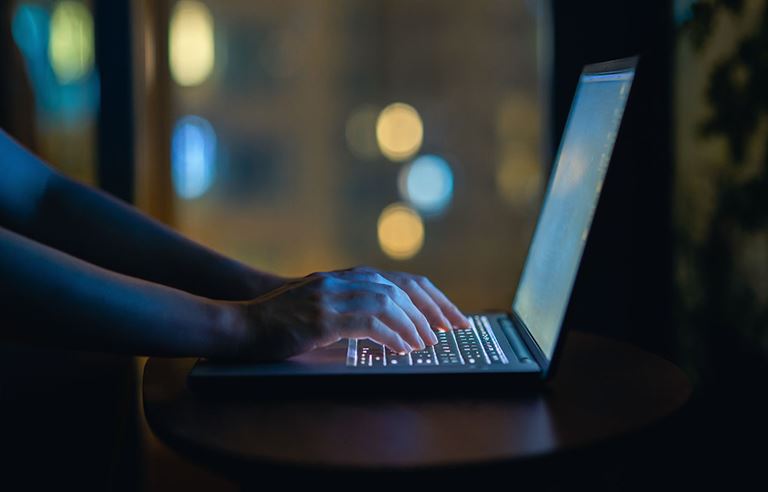 Hands typing on laptop computer.