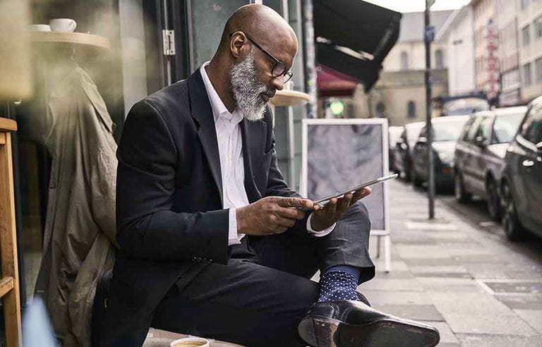 Business professional in a suit reading a newspaper.