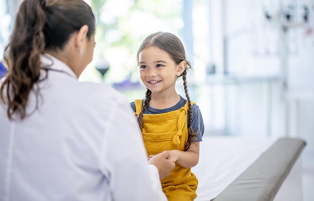 Little girl talking to doctor at doctors appointment.