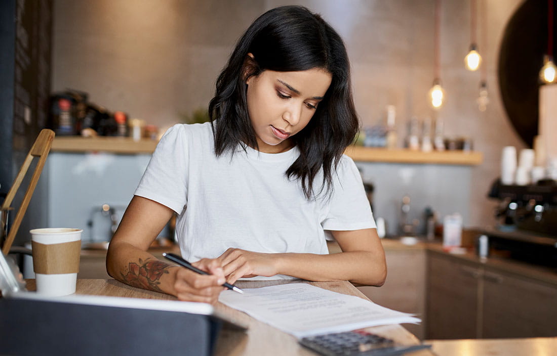 Person using calculator to help them fill out taxes.